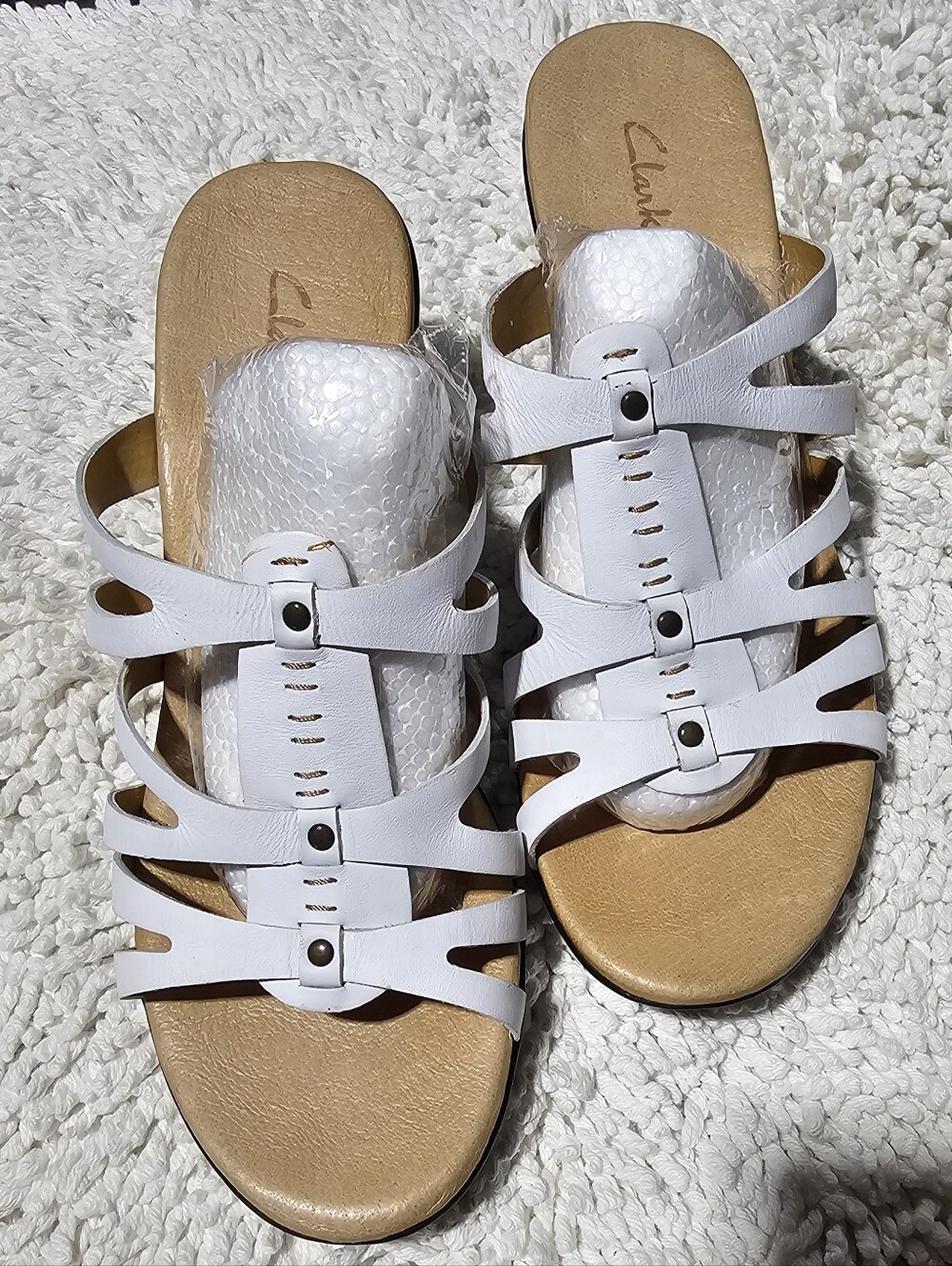 Clarks Bendables white leather multi-strap slide sandals.
